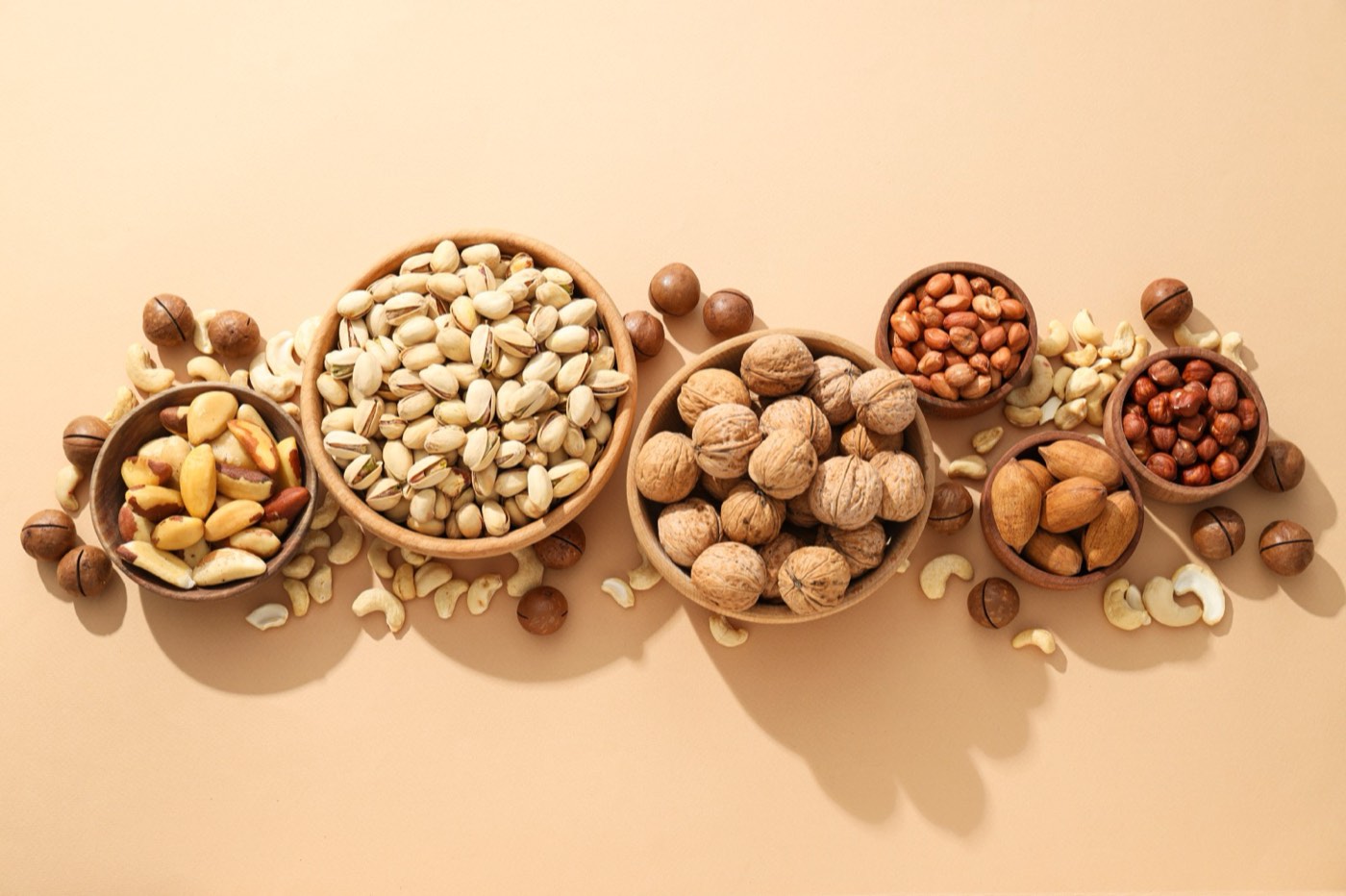 Wooden bowls of almonds, pistachios, walnuts, hazelnuts and cashews